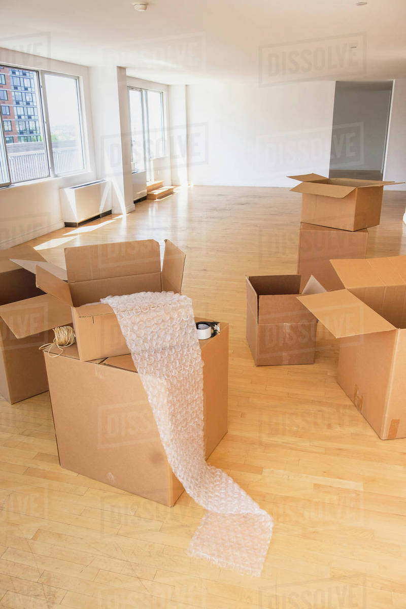 Cardboard boxes and bubble wrap in empty apartment Stock Photo Dissolve