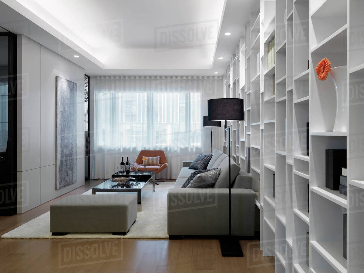 Modern living room with wall length bookcase Stock Photo Dissolve