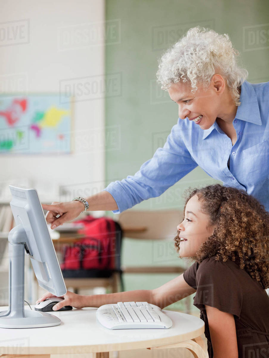 Teacher and student using computer - Stock Photo - Dissolve