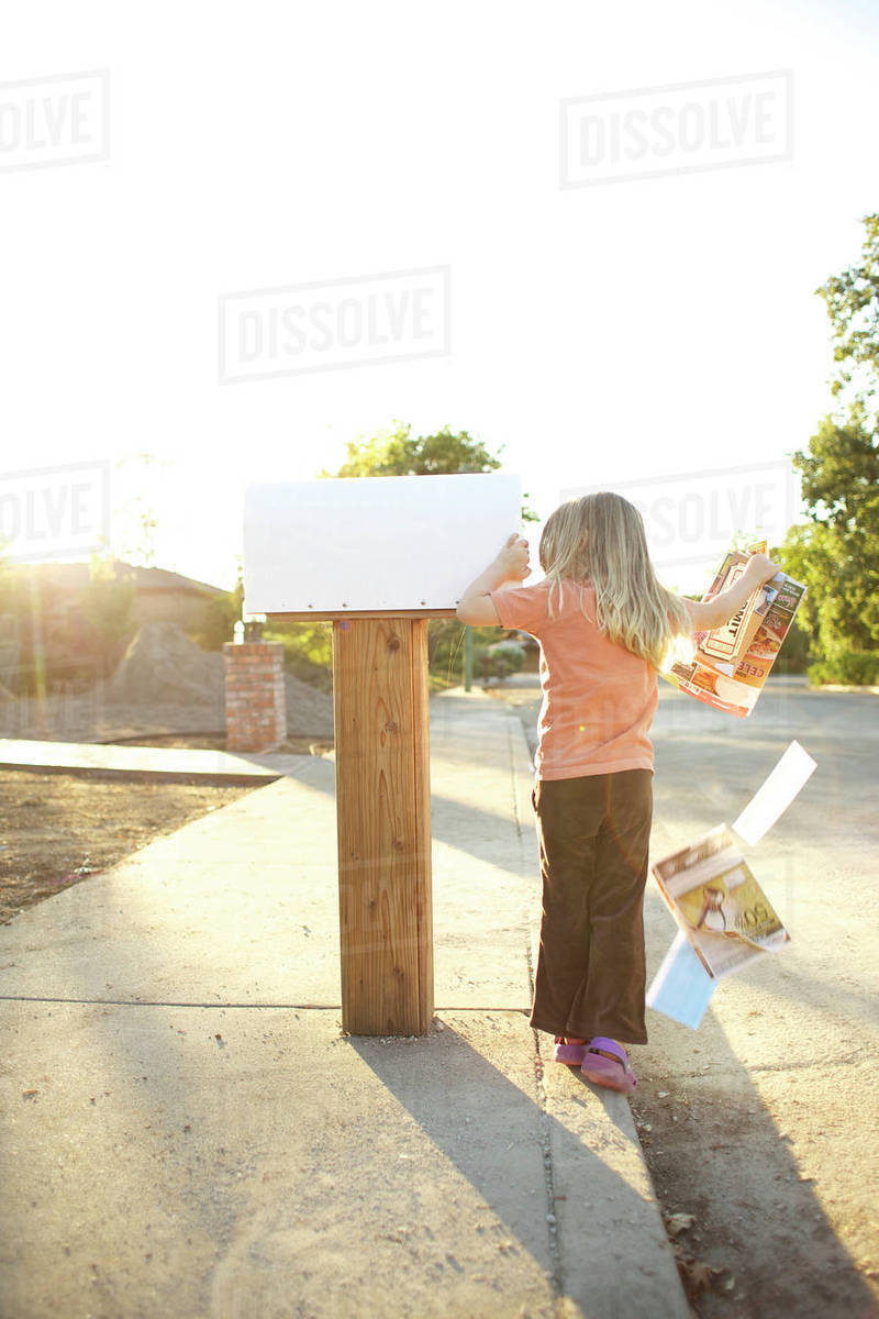 Caucasian man throwing mail out of mailbox Stock Photo Dissolve