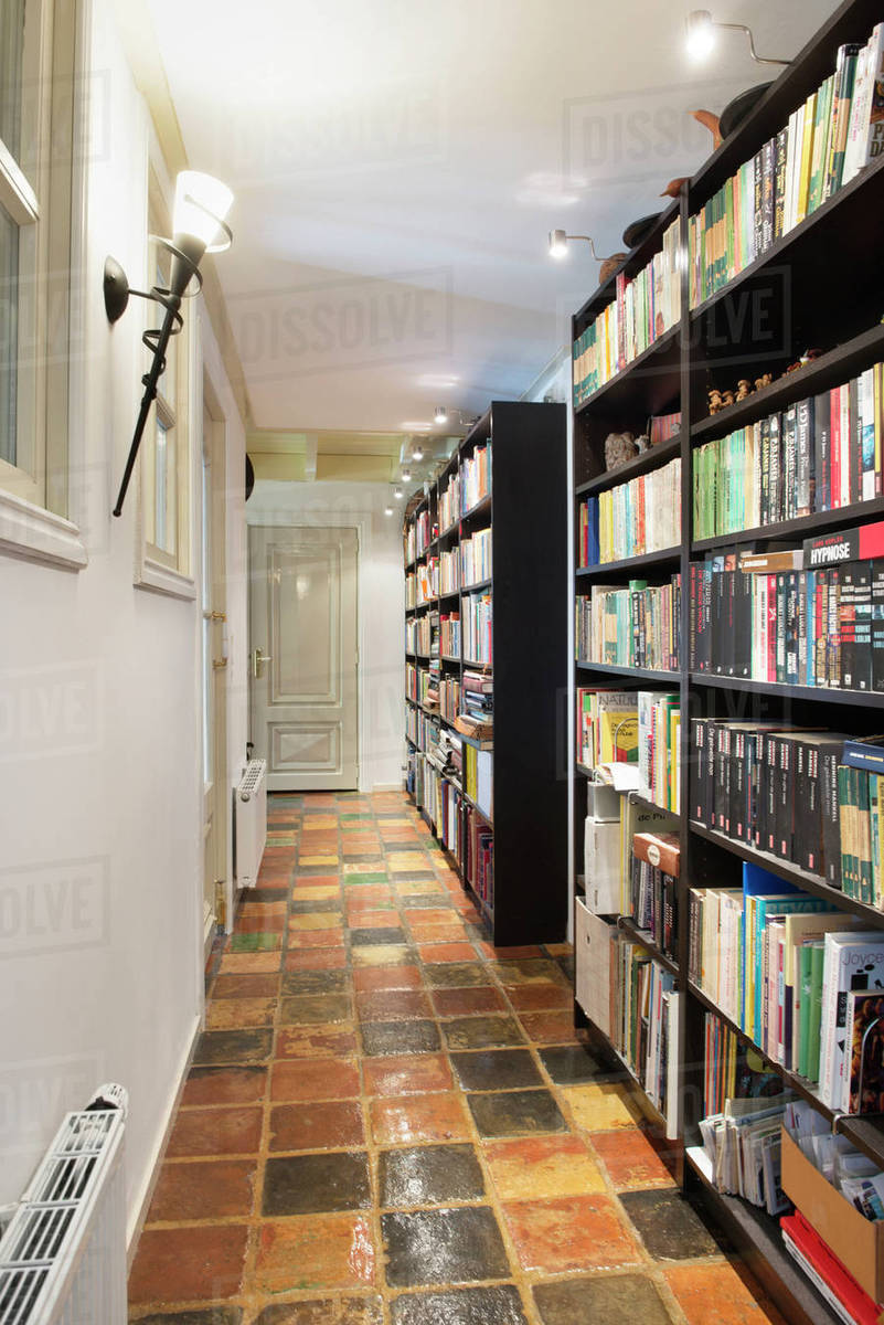 Interior of an empty library with rows of books on a shelf Stock