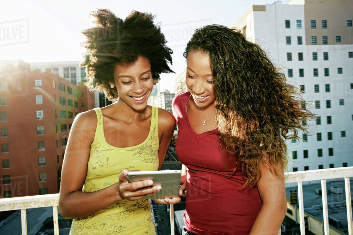 Mixed Race Women Using Digital Tablet On Urban Rooftop D145 225 095