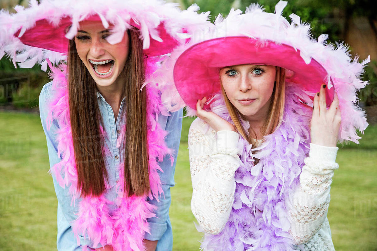 Caucasian teenage girls wearing feather boas and hats Stock Photo Dissolve