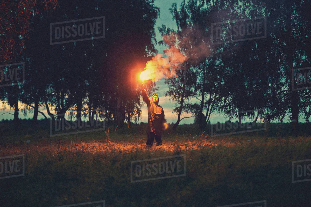 Caucasian man holding torch in field Stock Photo Dissolve