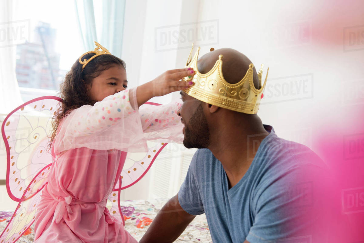 Daughter wearing costume placing crown on father Royalty-free stock photo