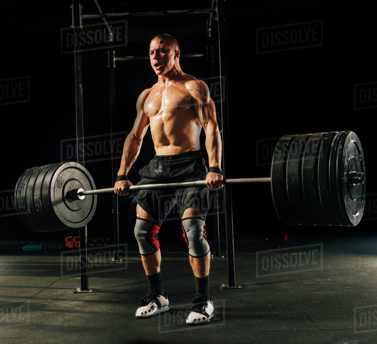 Man lifting heavy barbell in gymnasium Stock Photo Dissolve