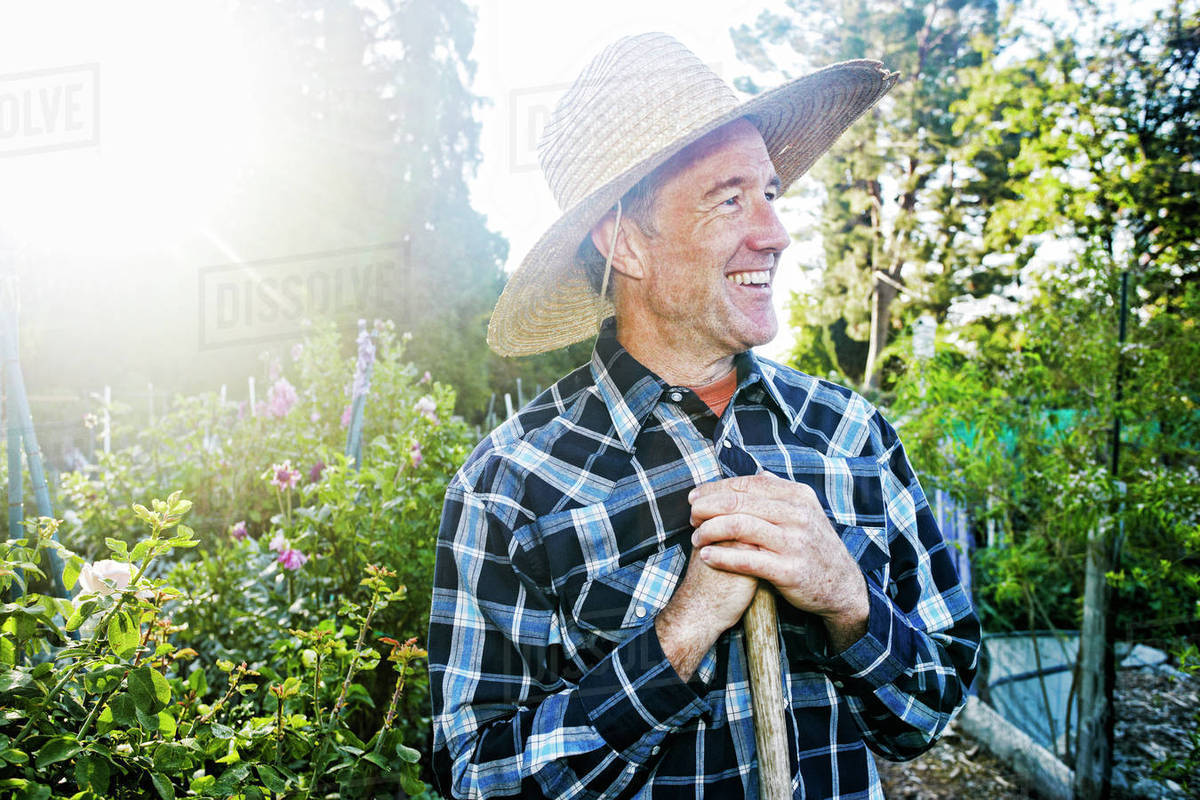 Smiling Caucasian man standing in garden Stock Photo Dissolve