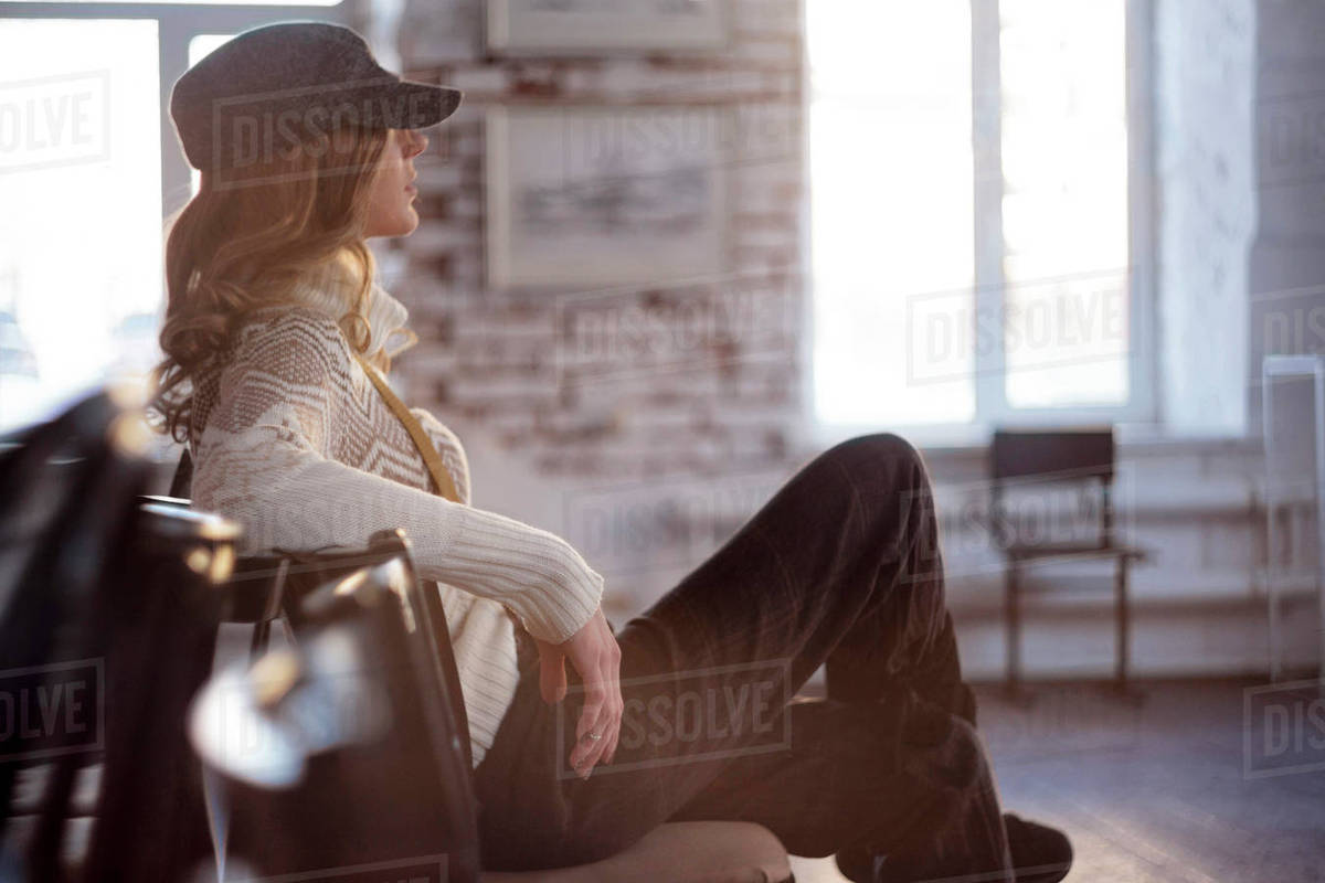 Woman sitting in chair with legs crossed Stock Photo Dissolve