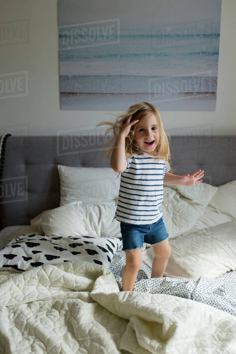 Girl jumping on bed Stock Photo Dissolve