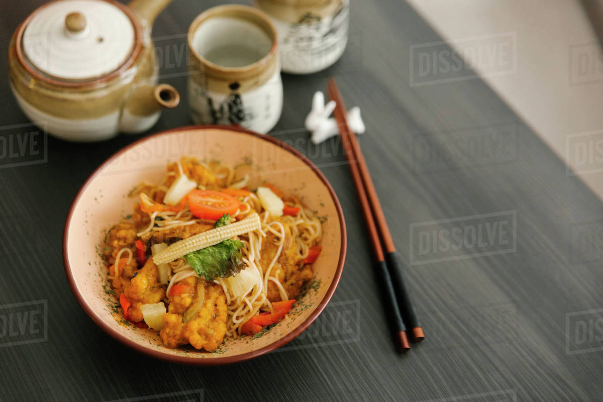Chopsticks near bowl of food Stock Photo Dissolve