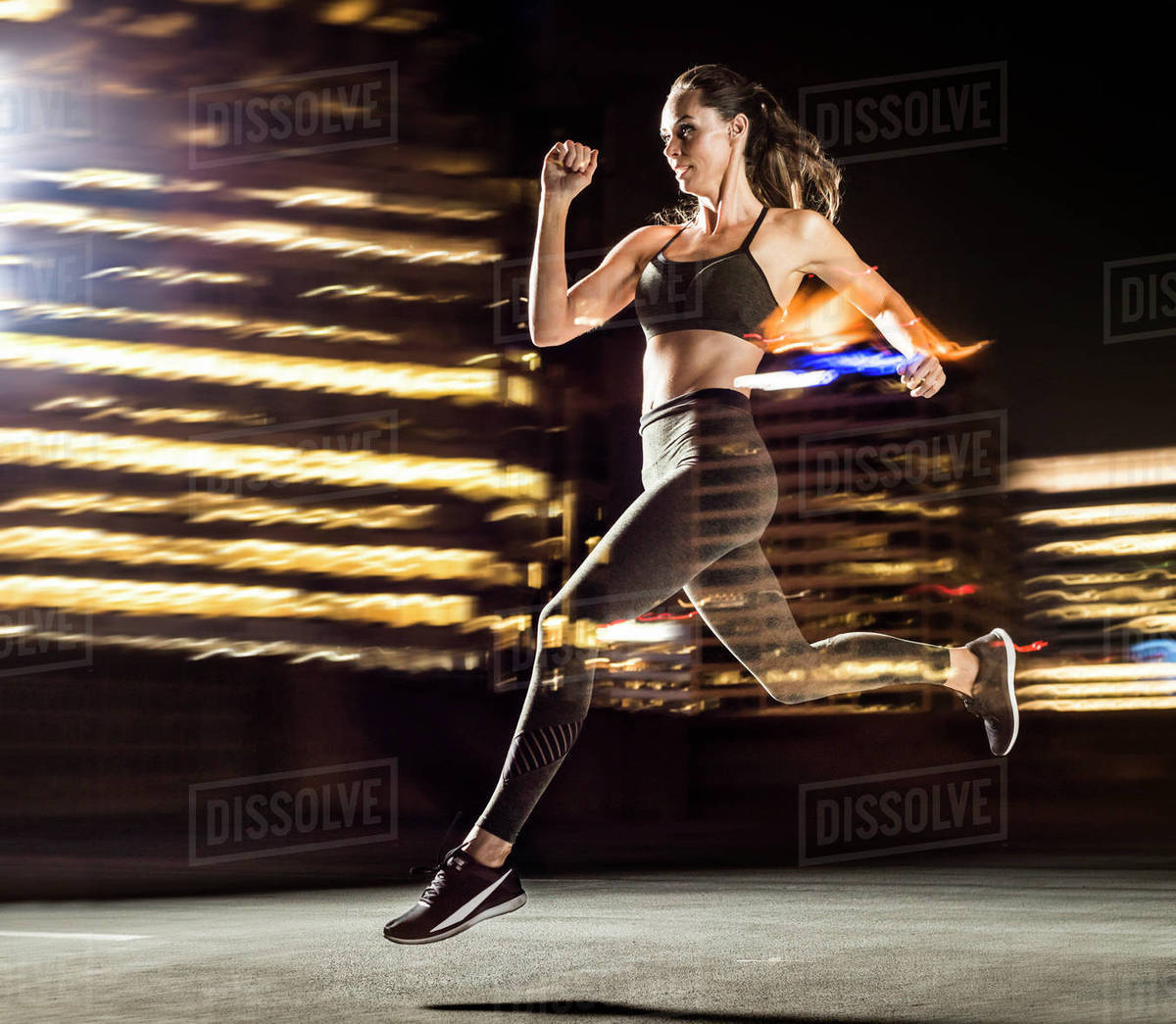 Double exposure of Caucasian woman running in city at night Stock