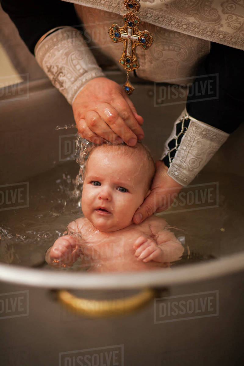 Caucasian baby boy being baptized Stock Photo Dissolve