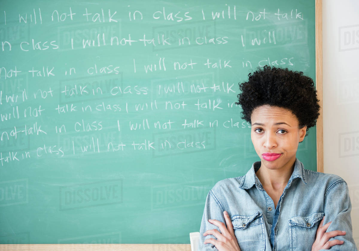 Black woman writing lines on chalkboard - Stock Photo - Dissolve