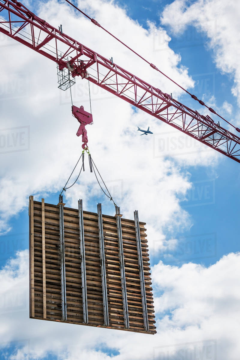 Crane lifting concrete wall form on construction site Stock Photo