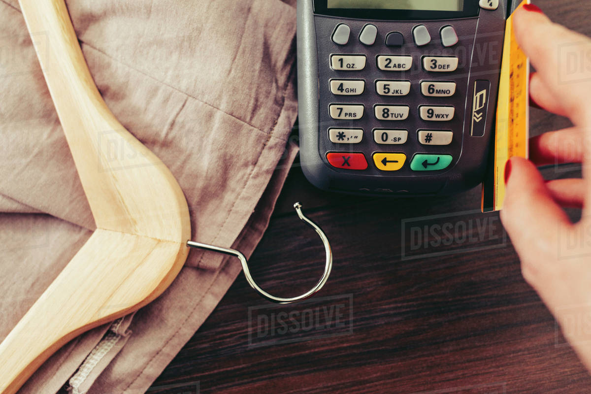 Woman swiping credit card through credit card reader Stock Photo