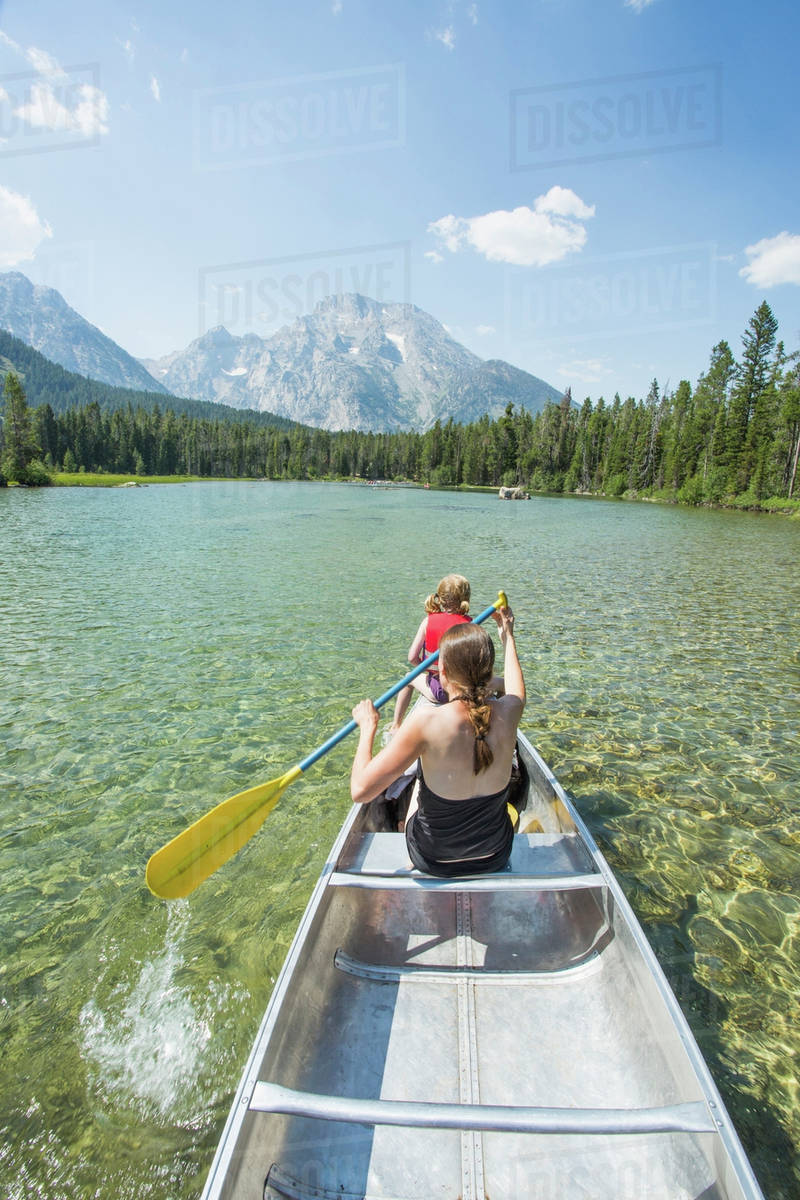 Caucasian mother and daughter paddling canoe on lake Stock Photo