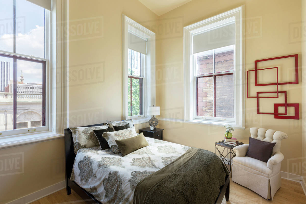 Bed and armchair in bedroom Stock Photo Dissolve