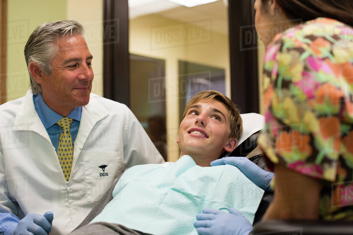 Dentist and nurse talking to patient Stock Photo Dissolve