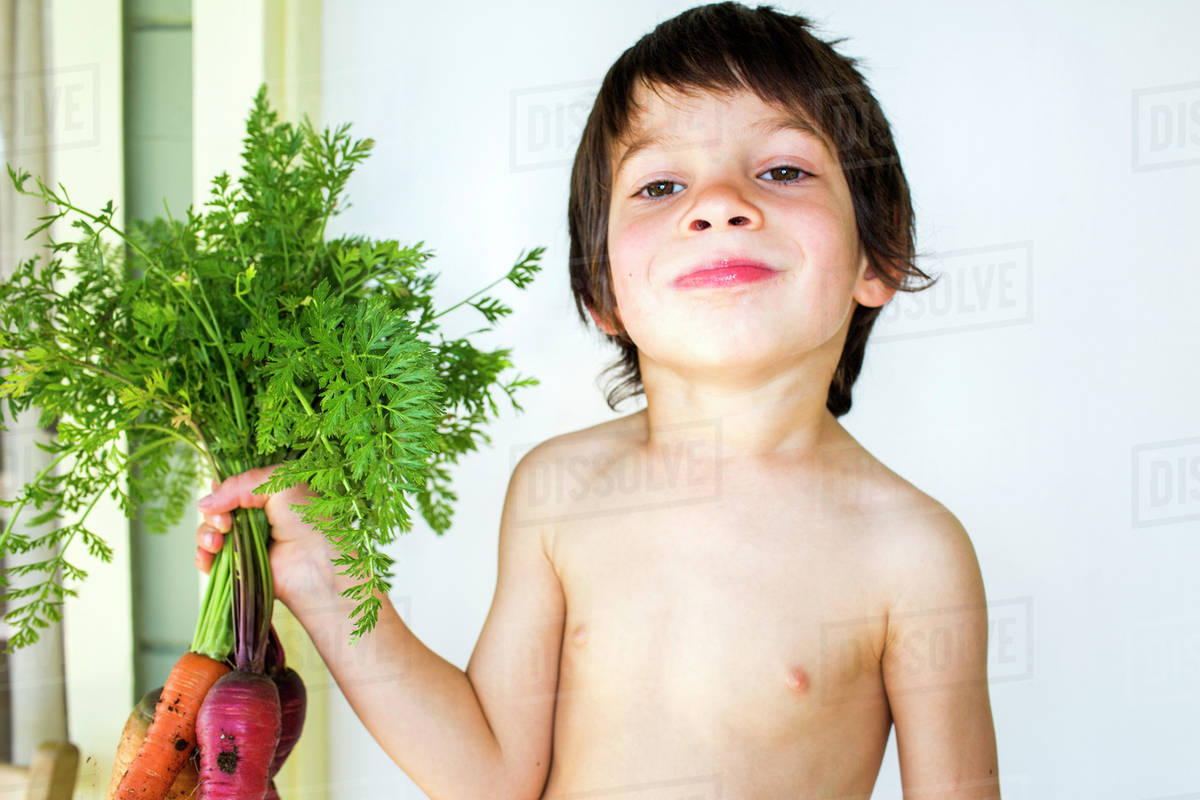 Mixed Race Boy Holding Fresh Picked Carrots Stock Photo Dissolve