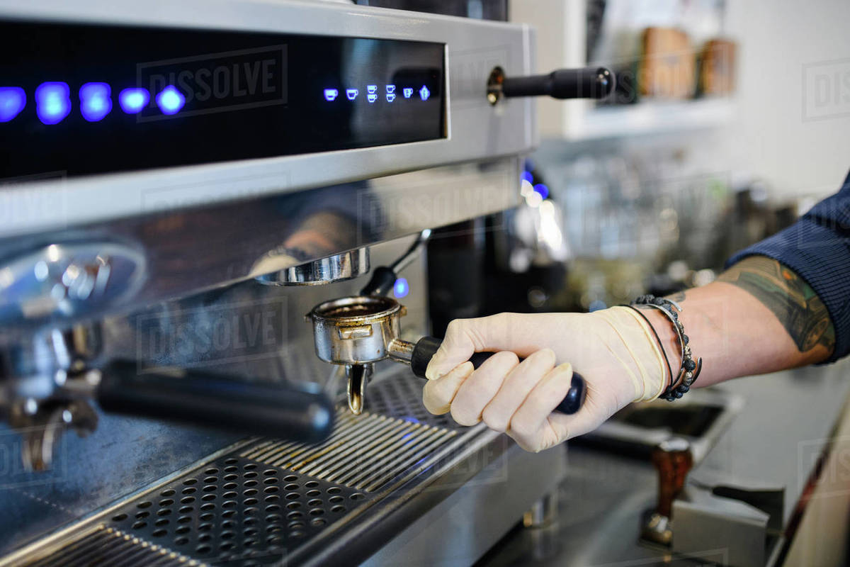 Unrecognizable barista working with gloves, coffee shop open after