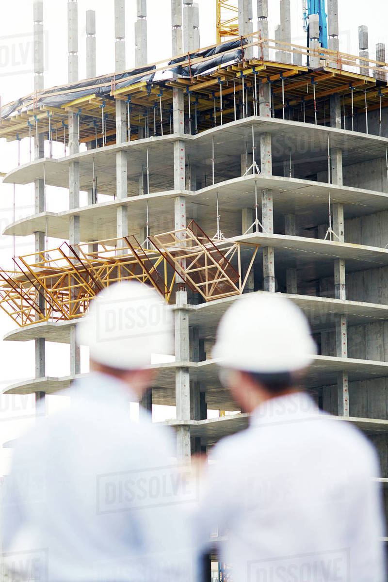 Unfinished structure with two architects near by - Stock Photo - Dissolve