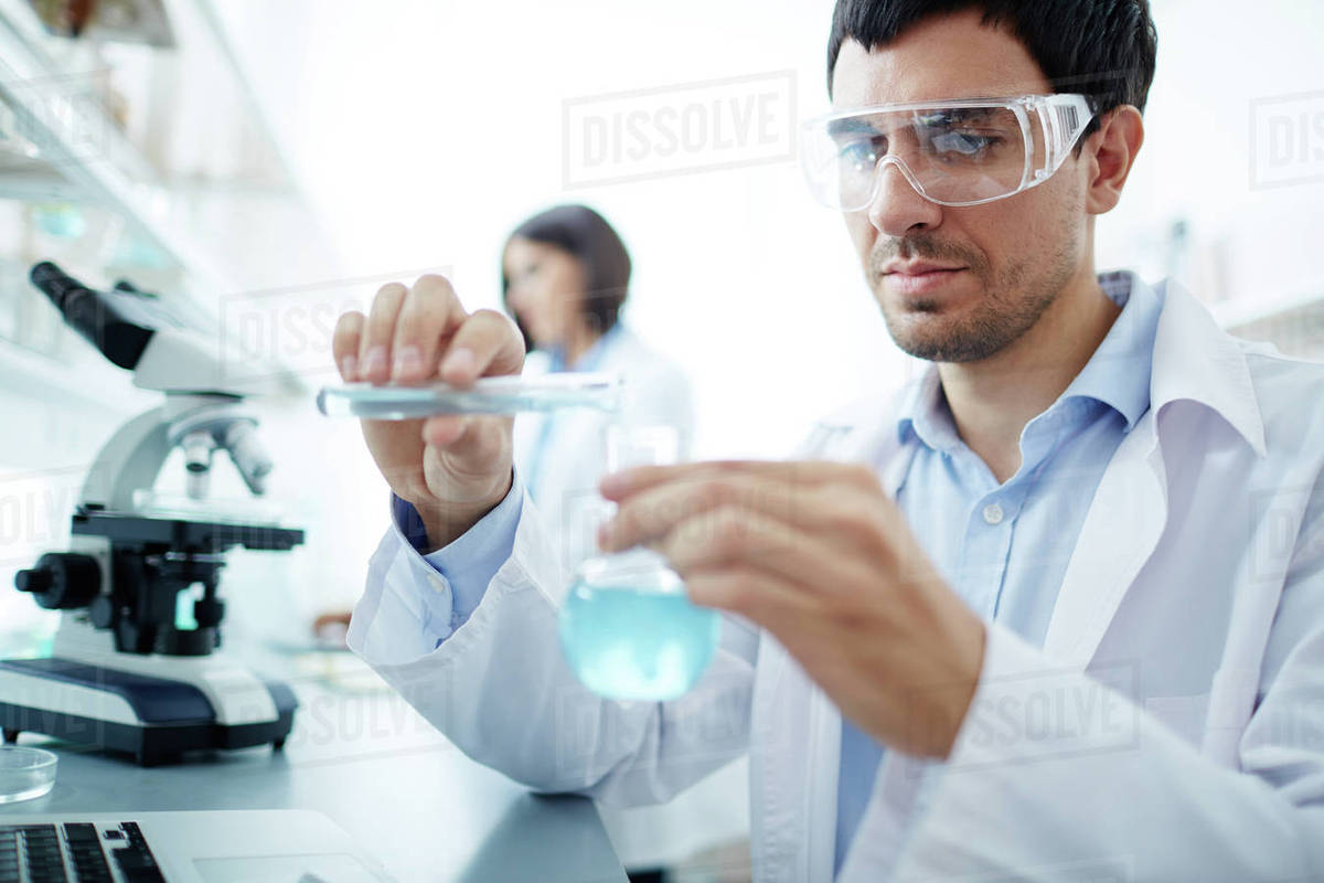 Lab worker in uniform testing substance Stock Photo Dissolve