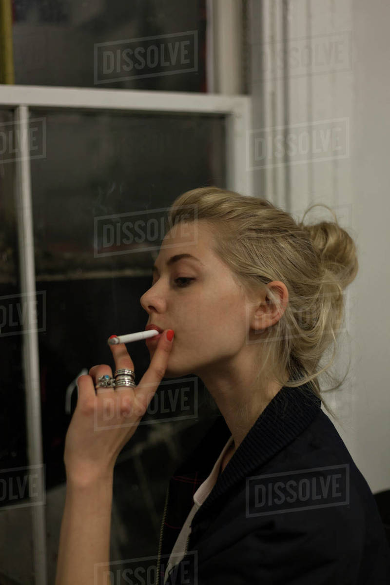 smoking a cigarette pose Young woman posing with a cigarette - Royalty-free Stock Photo