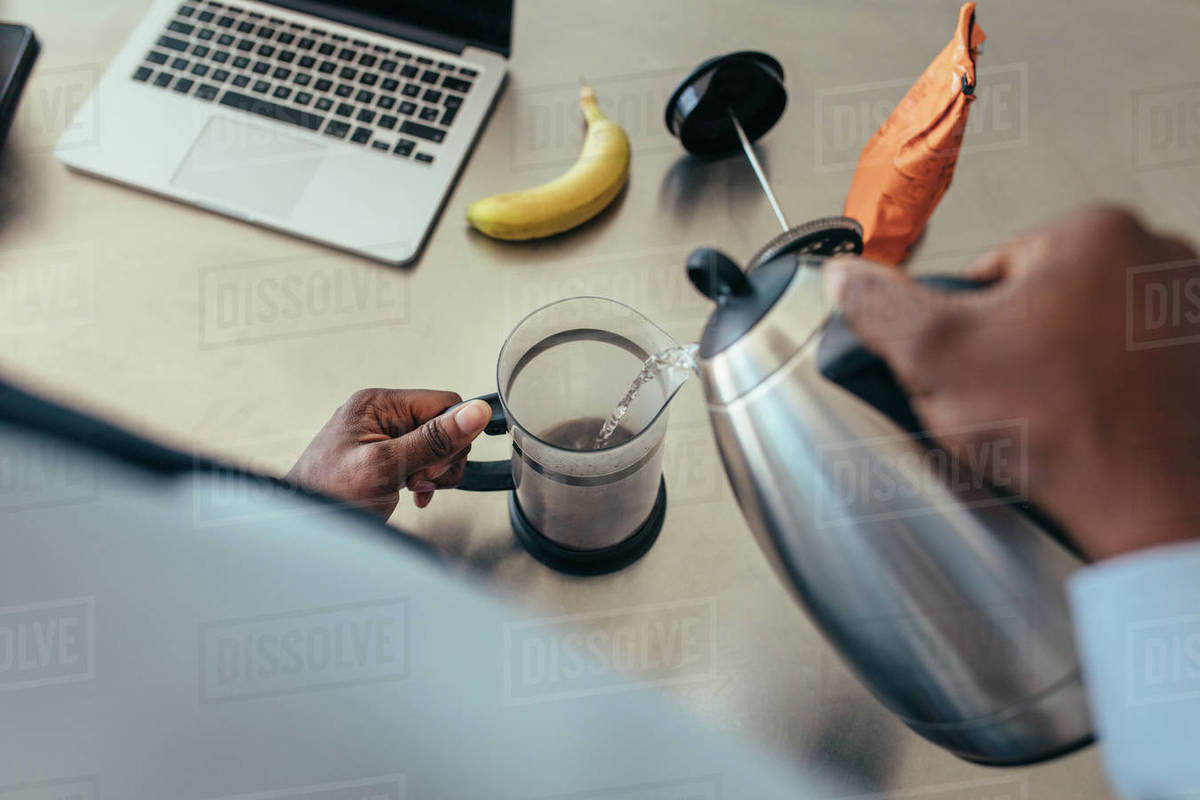 Man pouring hot water in coffee maker. Man preparing coffee on