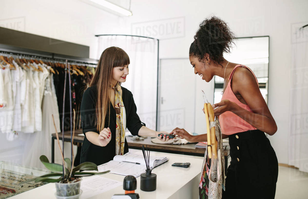 Customer shopping designer wear at a fashion boutique. Customer making