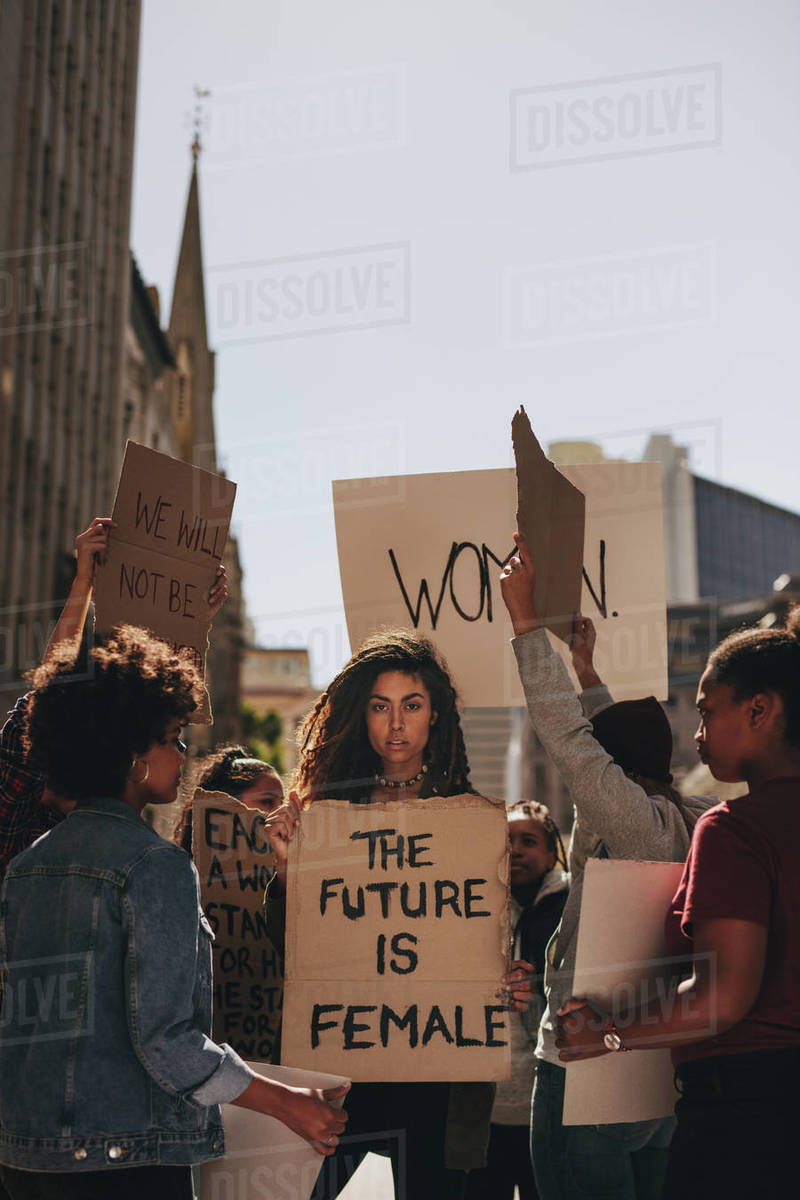 Woman holding a protest sign about women empowerment. Group of women ...