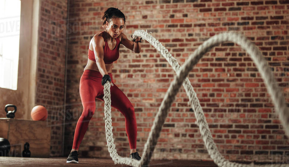 Athlete moving the ropes in wave motion as part of fat burning workout