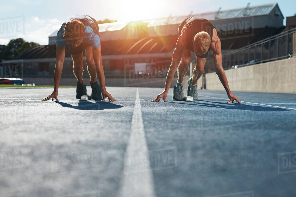 Sprinters at starting blocks ready for race . Athletes at starting