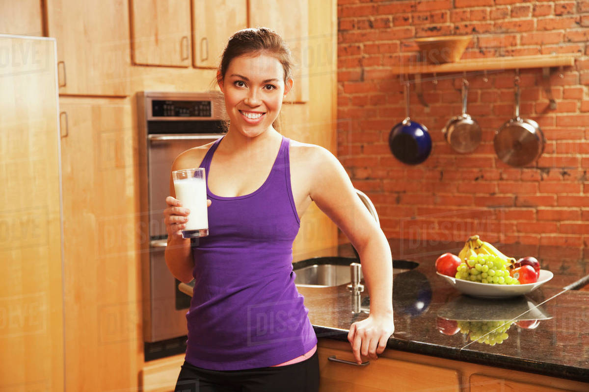 Hispanic woman drinking milk after exercise Stock Photo Dissolve