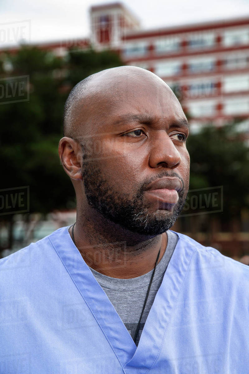 Portrait of middle aged man with beard and a bald head wearing scrubs