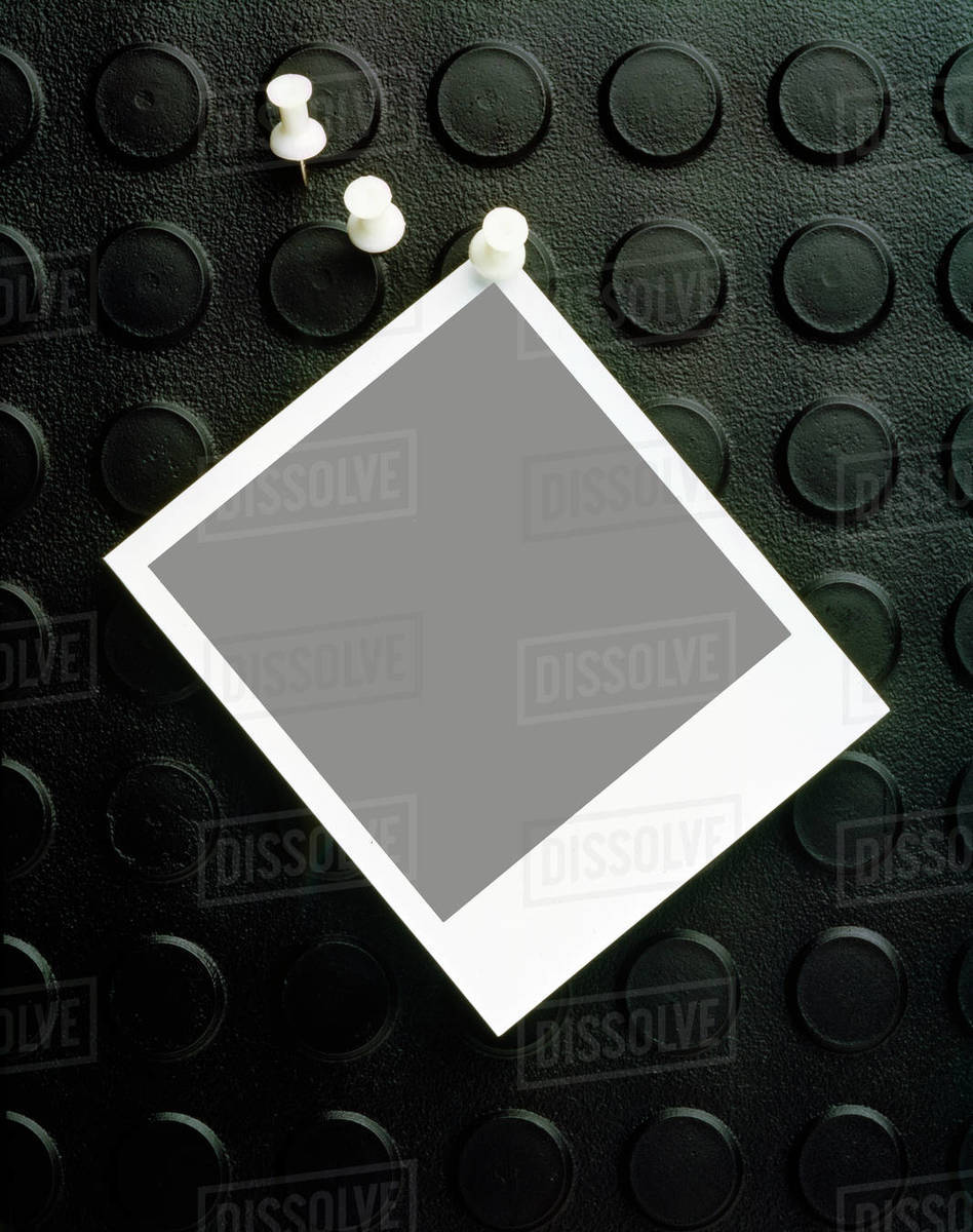 Blank polaroid pinned to rubber pinboard Stock Photo Dissolve