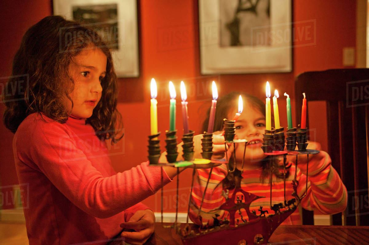 Two young girls lighting Chanukah candles. Stock Photo Dissolve