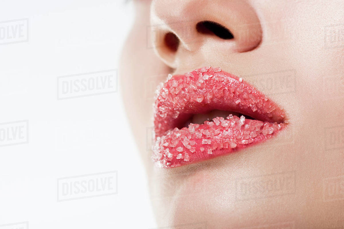 Cropped view of woman with sugar on pink lips, isolated on white ...