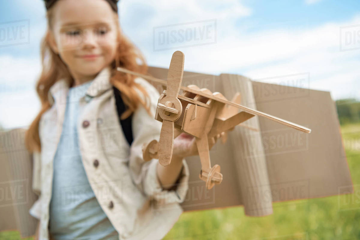 Selective Focus Of Red Hair Kid In Pilot Costume Holding Wooden