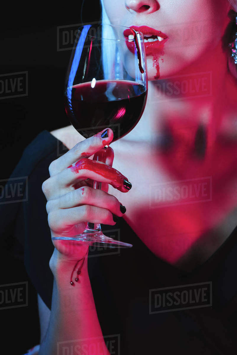 Cropped view of vampire drinking blood from wineglass isolated on black -  Royalty-free Stock Photo | Dissolve