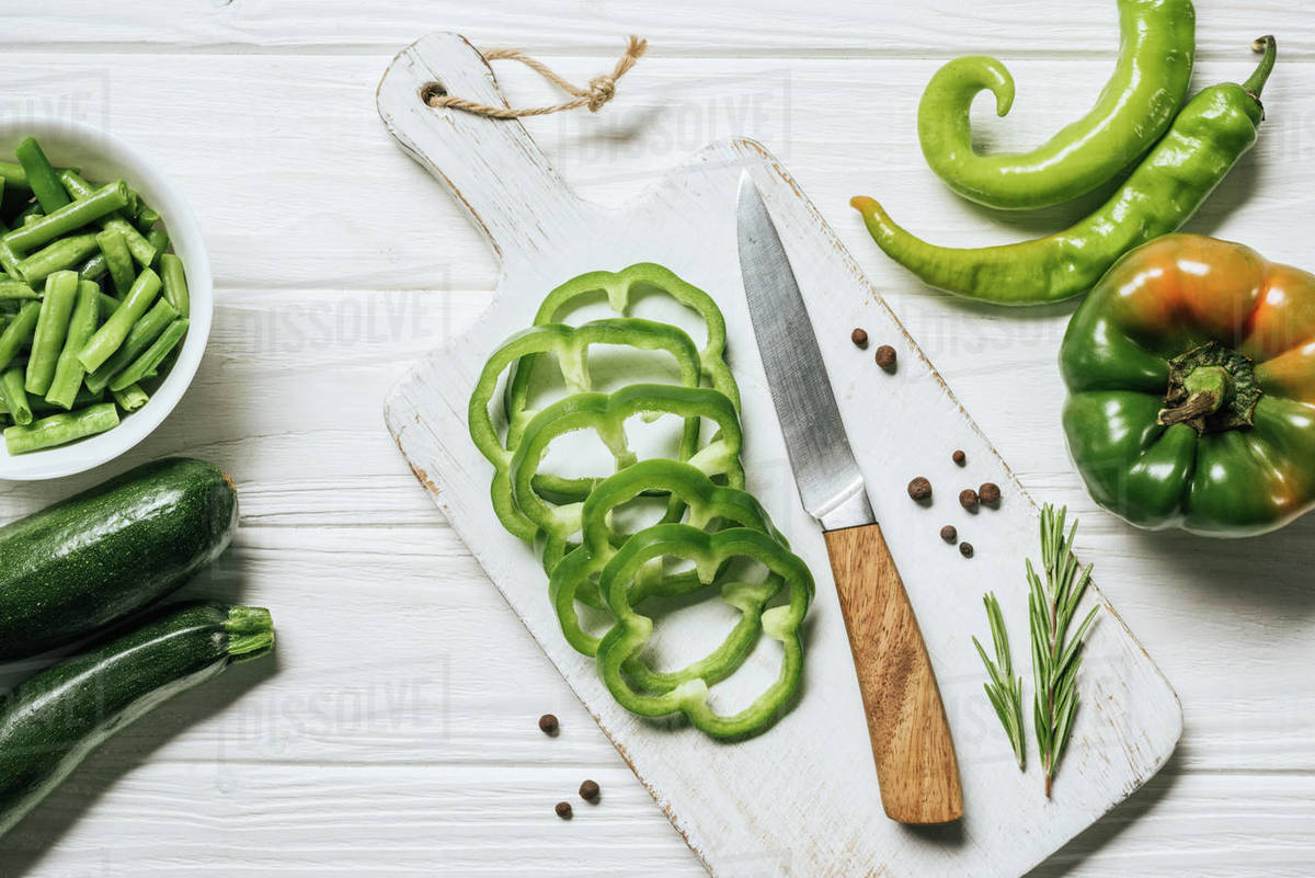 Top view of cut green bell pepper on white wooden cutting board Stock