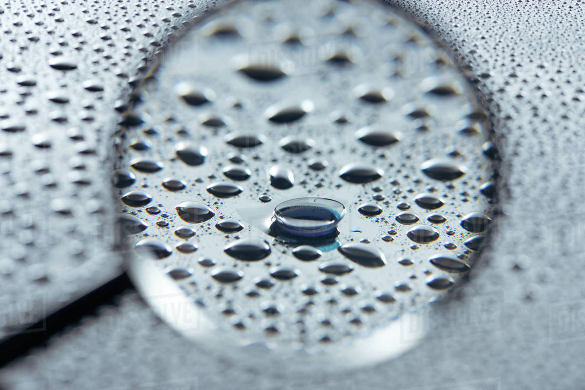 Selective focus of magnifying glass and contact lense on grey