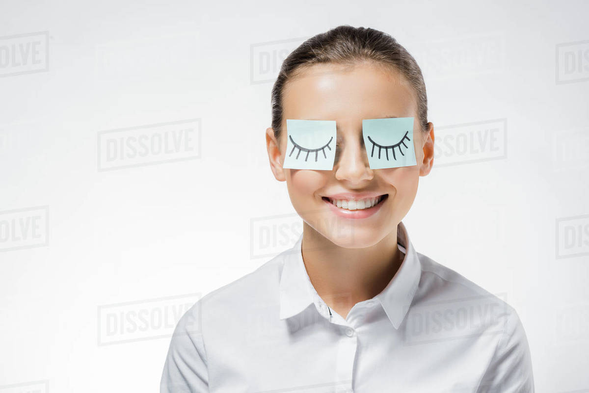 Young smiling woman with sticky notes on eyes and drawn eyelashes ...