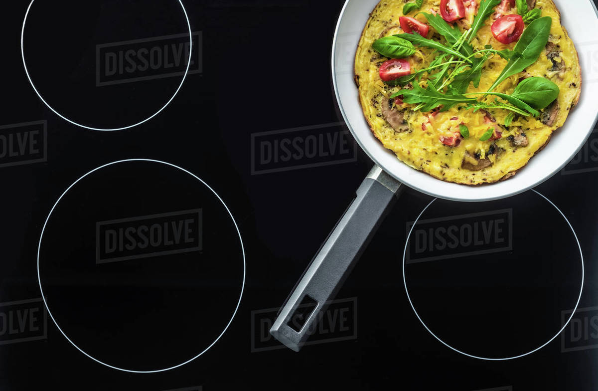 Top view of omelets in frying pan cooking on black stove Stock Photo