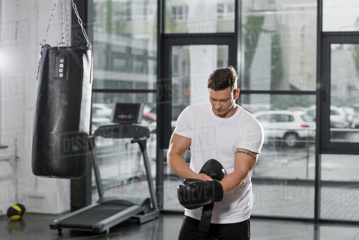 Handsome muscular boxer wearing boxing gloves in gym Stock Photo