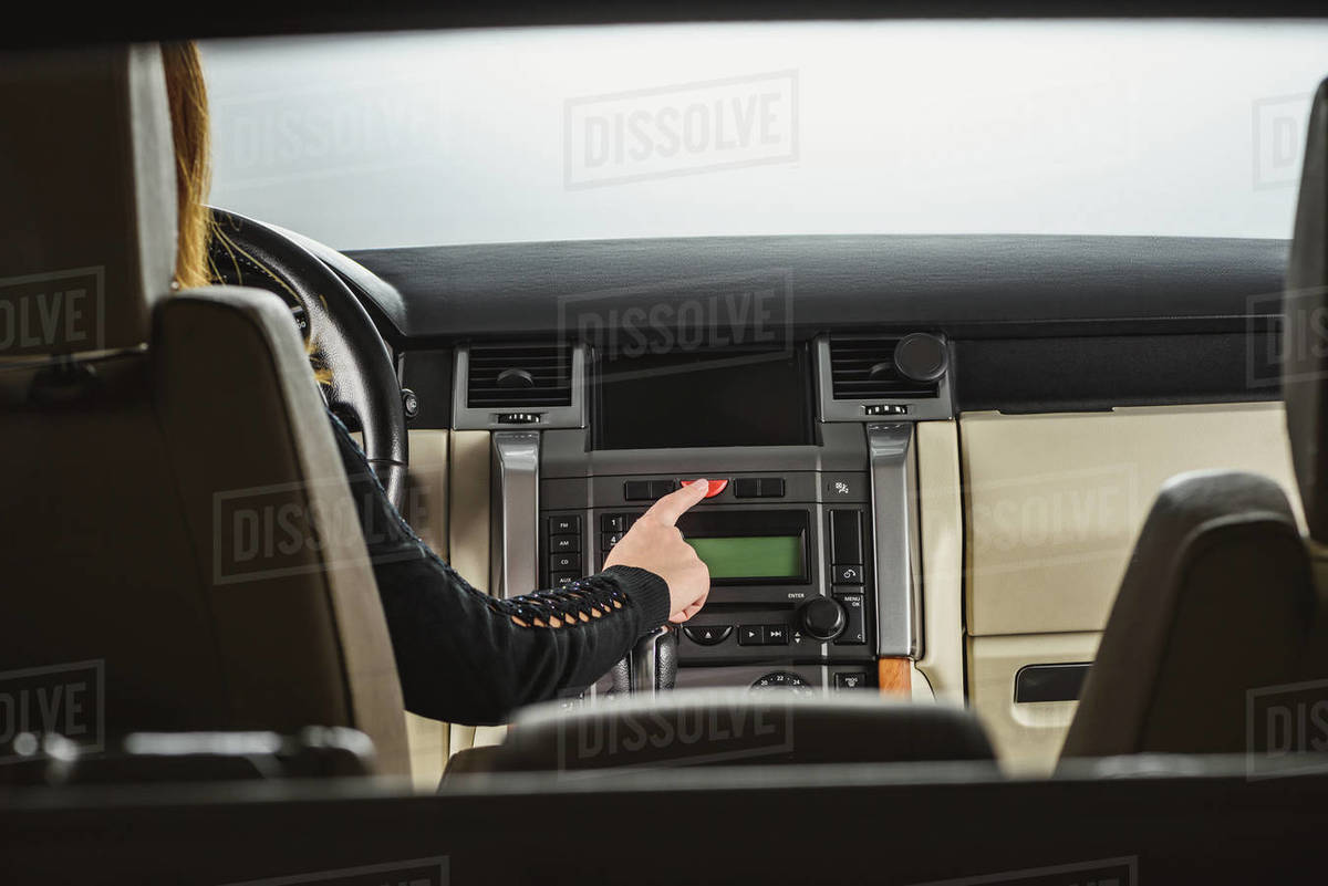 Cropped shot of woman turning on hazards while driving car Stock