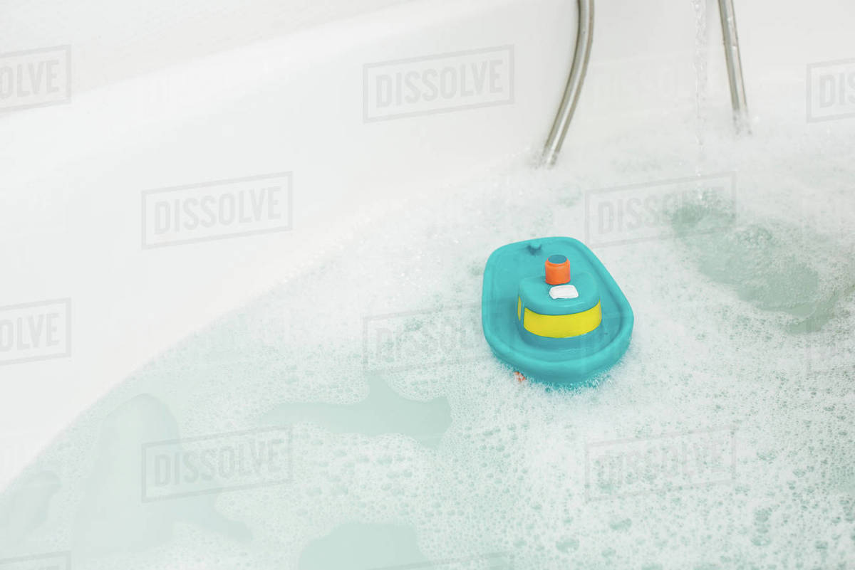 White bathtub with water and bath toy Stock Photo Dissolve