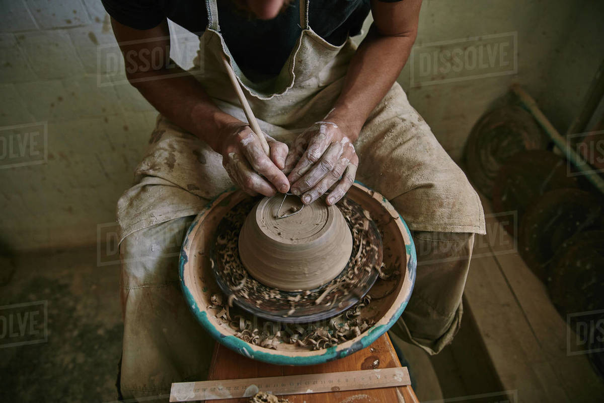 cropped image of professional potter decorating clay pot at