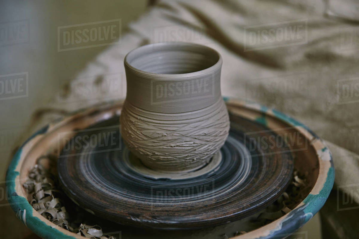 selective focus of clay pot on pottery wheel at Stock Photo