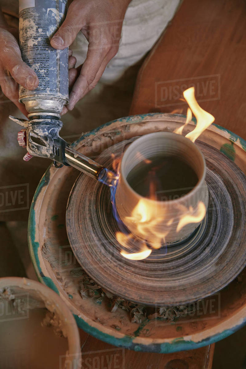 cropped image of male potter firing clay pot at pottery studio Stock