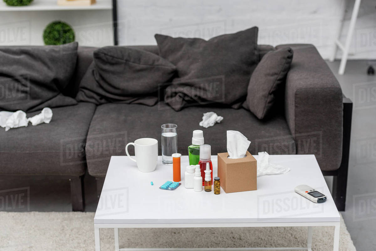 Table with various medicines and couch at living room Stock Photo